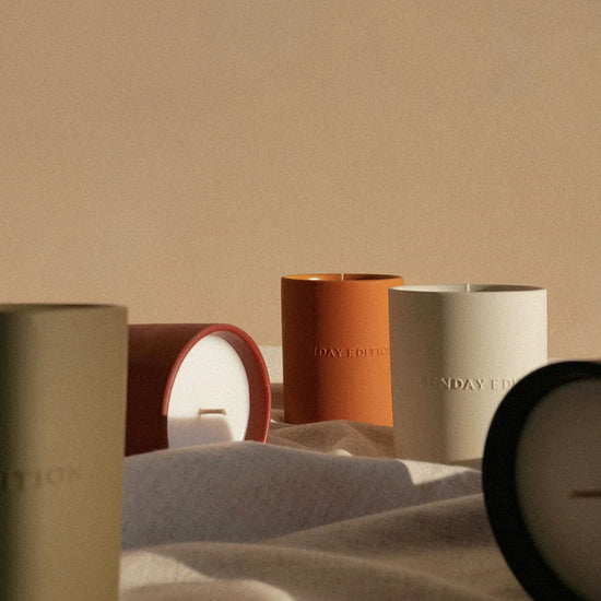 Set of candles with visible brand names on a neutral background