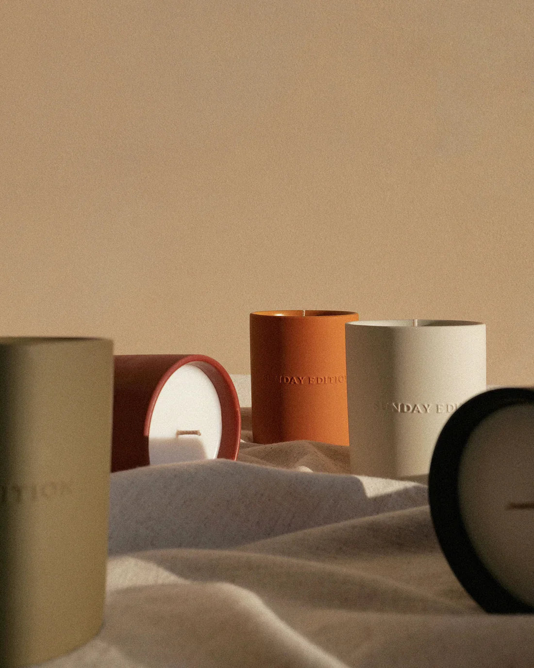 Set of candles with visible brand names on a neutral background