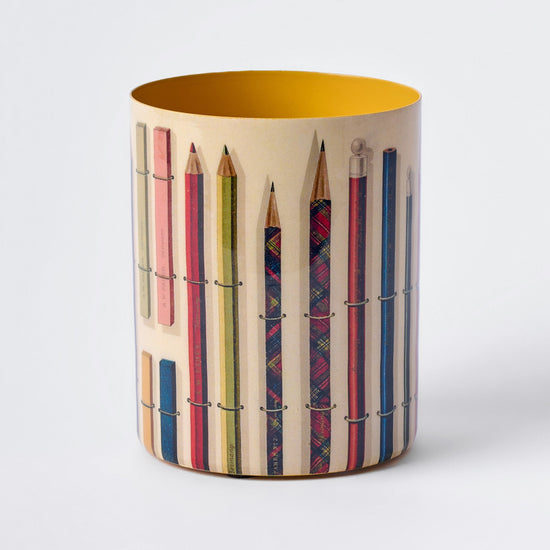 Cylindrical container with patterned pencils design on a white background