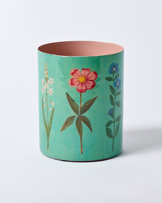 Teal cylindrical container with floral designs on a white background