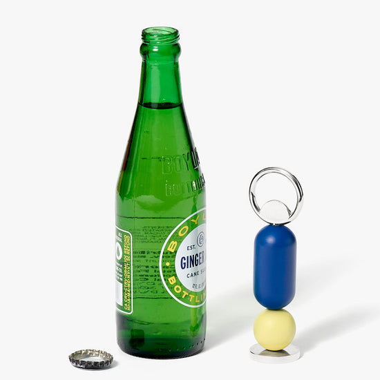 Green bottle with a bottle opener keychain on a white background