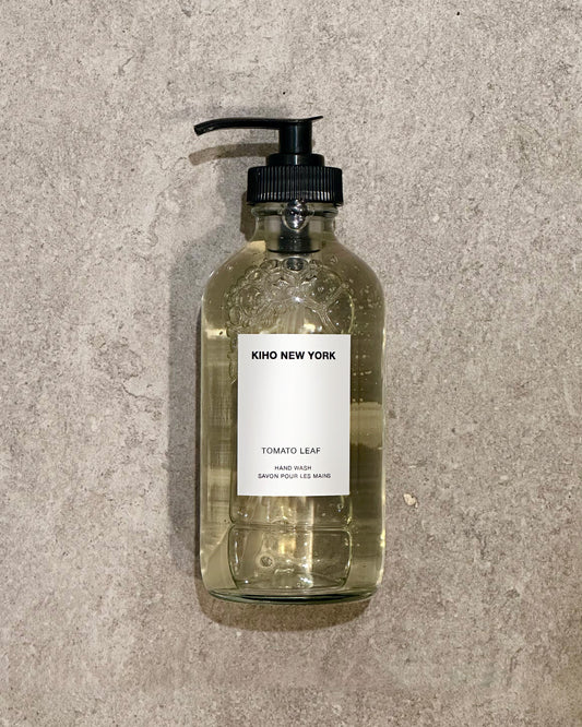 Glass bottle with pump and 'Kiho New York' label on a textured gray background