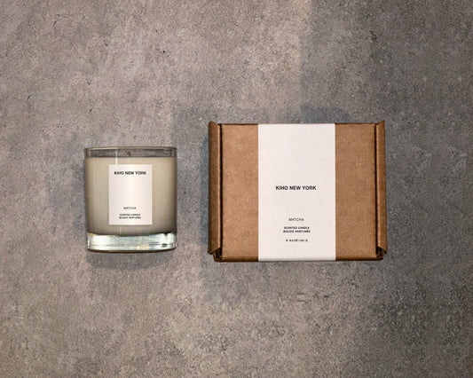 Candle and packaging box with 'Kiho New York' branding on a gray surface