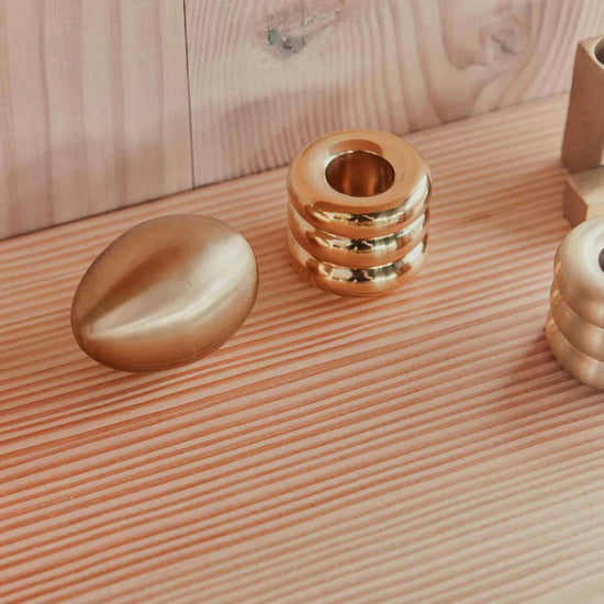 Gold handle holder with decorative items on a wooden surface