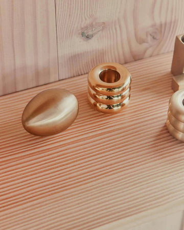 Gold handle holder with decorative items on a wooden surface