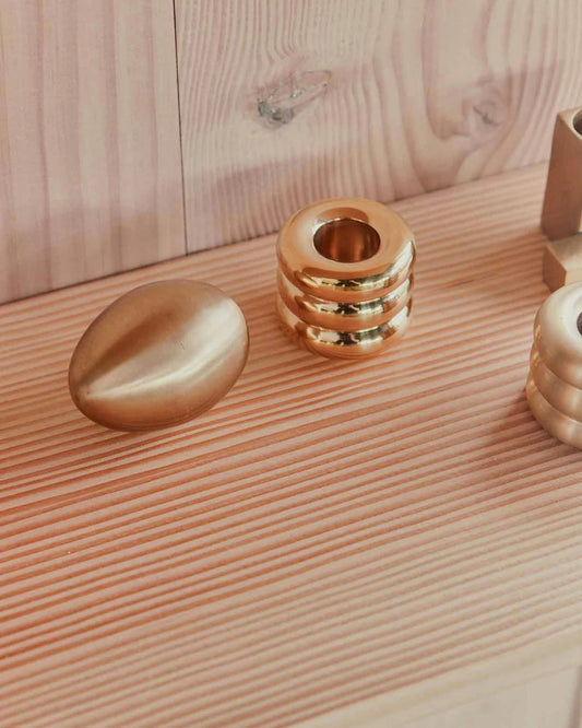 Gold handle holder with decorative items on a wooden surface