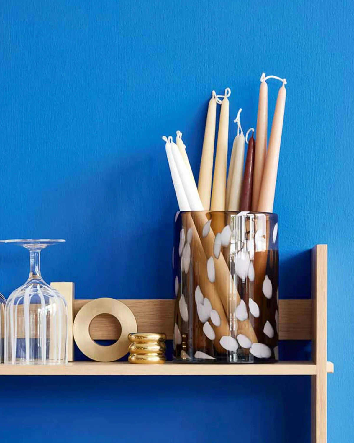 Decorative items including candles and a vase on a shelf against a blue wall