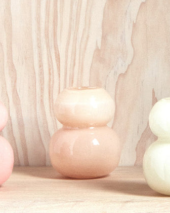 Two ceramic vases on a wooden surface with a neutral background