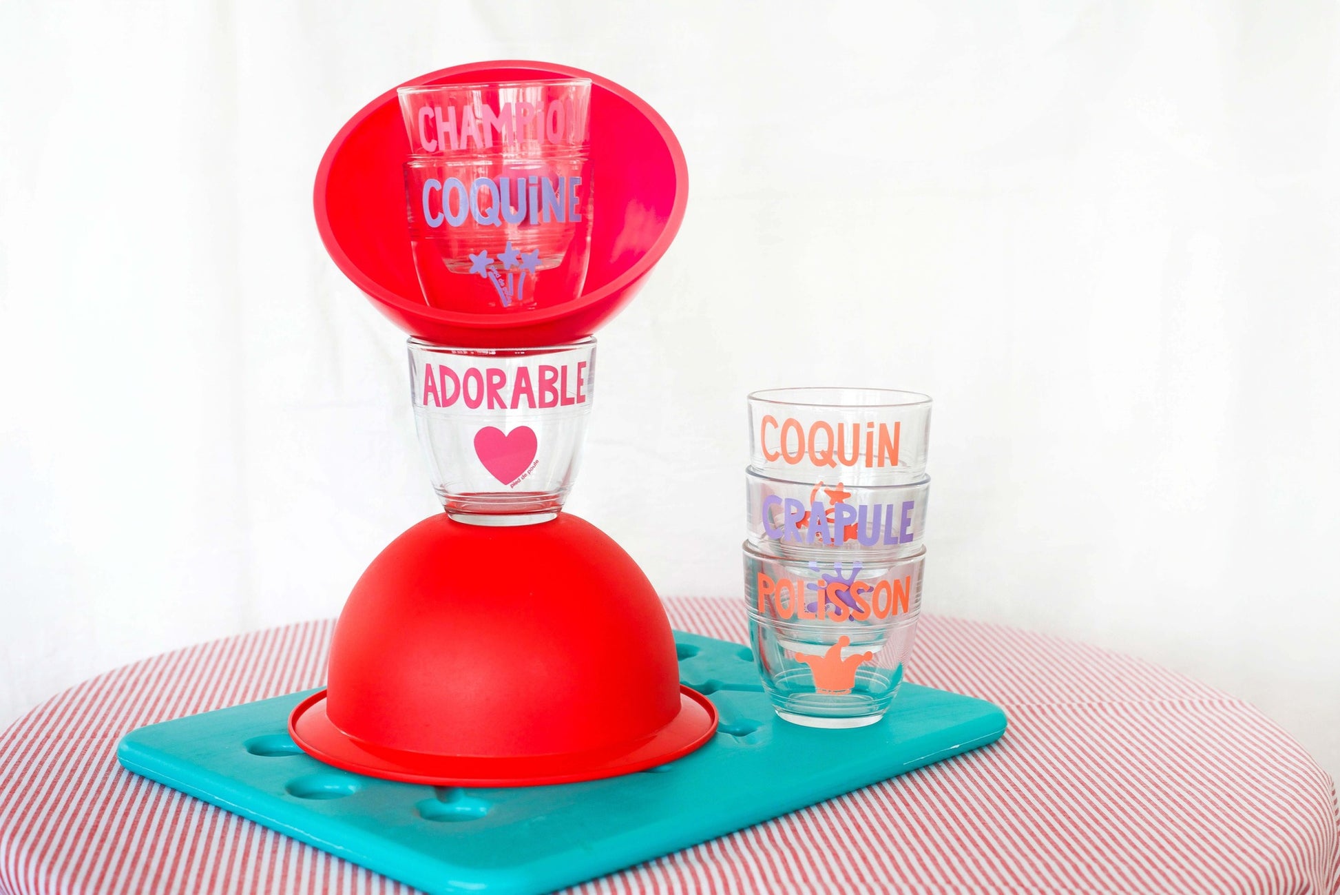 Red plastic stand with colorful cups on a white background
