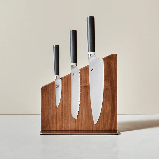 Set of knives with wooden holder on a neutral background