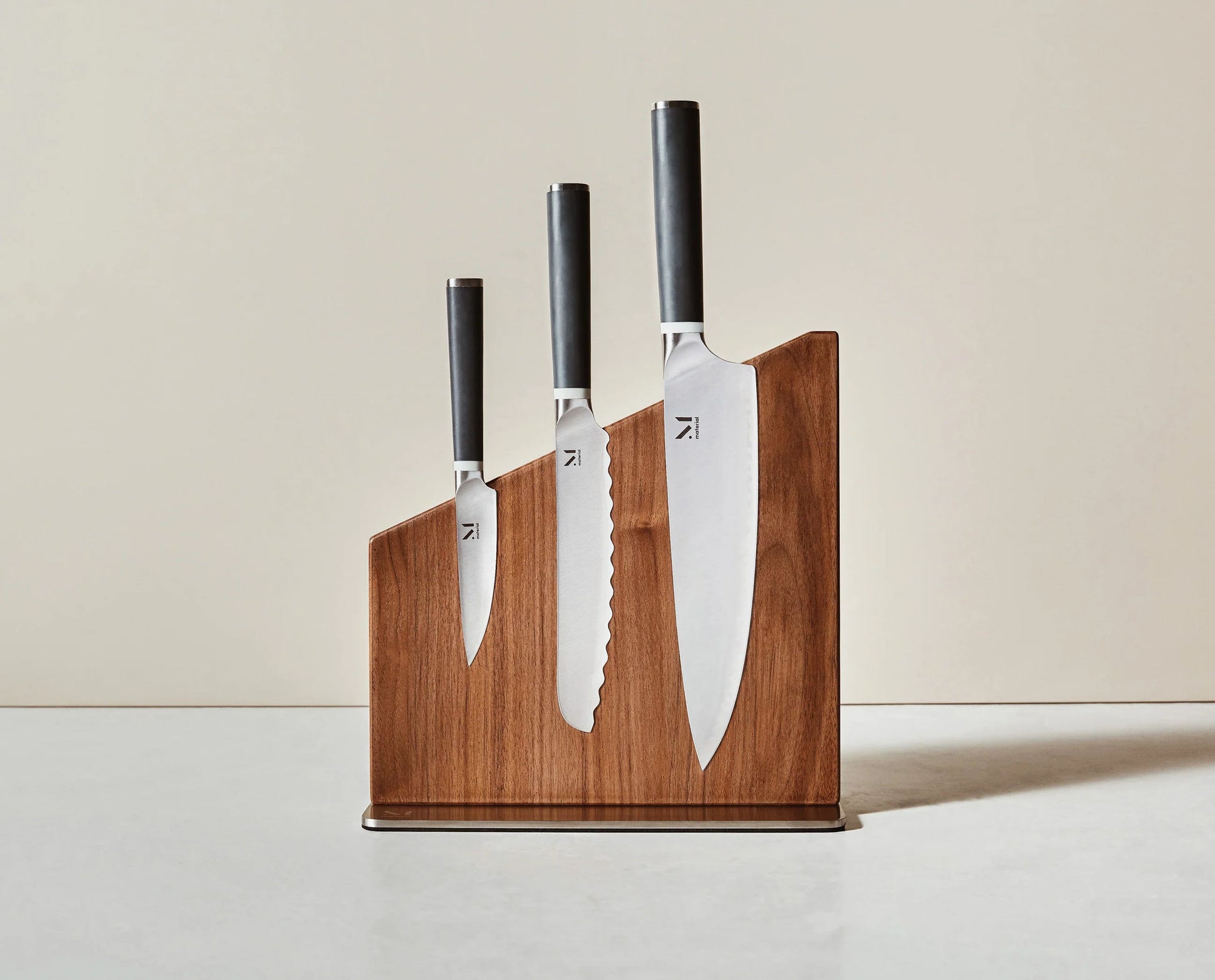 Set of knives with wooden holder on a neutral background