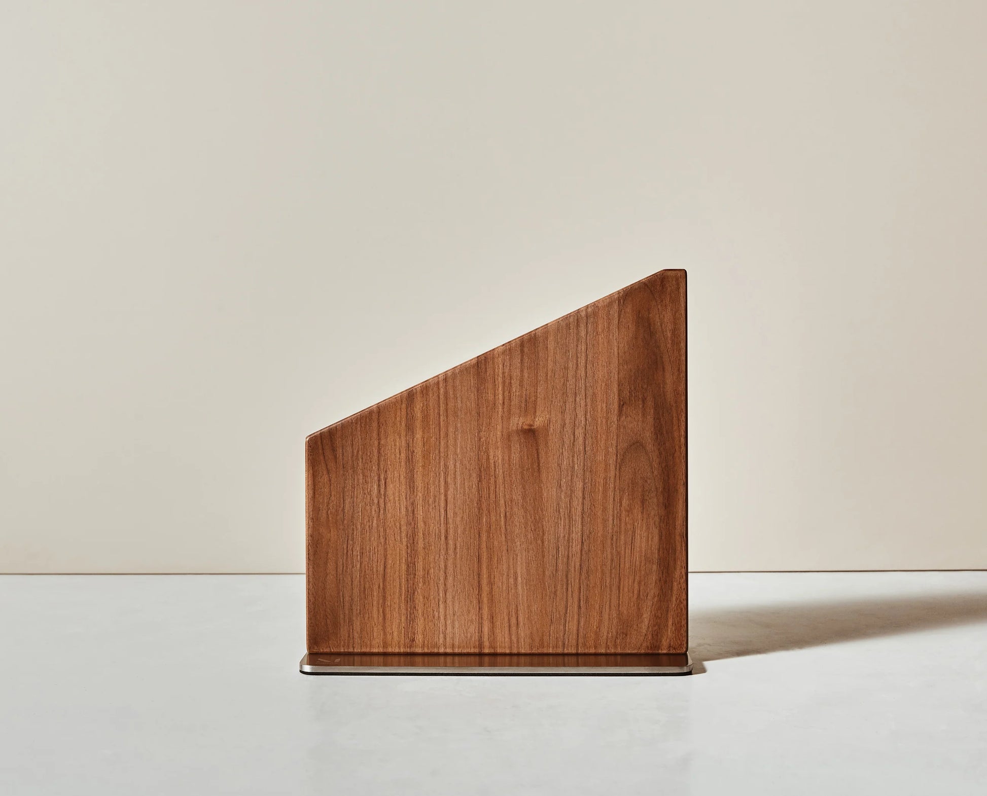 Wooden magnetic knife stand with a geometric design on a neutral background