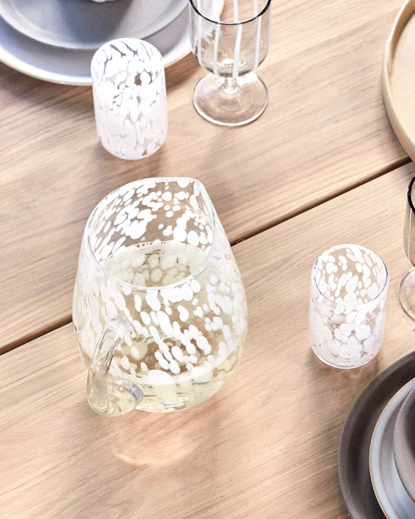 White ceramic pitcher with a textured surface on a white background