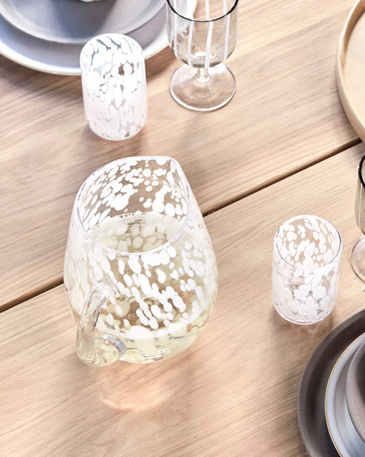 White ceramic pitcher with a textured surface on a white background