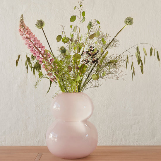 Rose color large vase with flower inside on the table