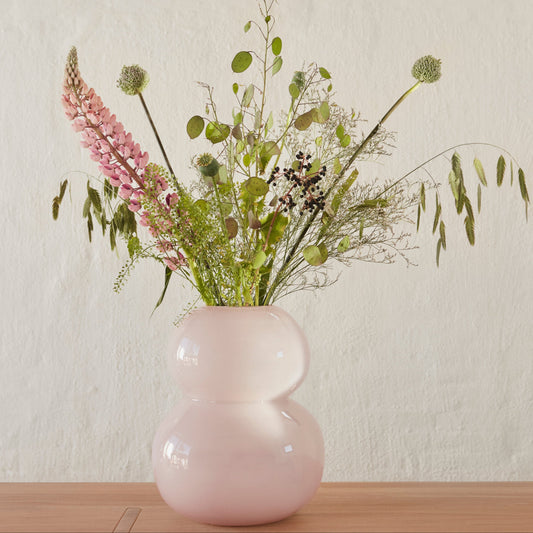 Rose color large vase with flower inside on the table