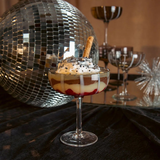 Dessert in a glass with a disco ball and other glasses in the background