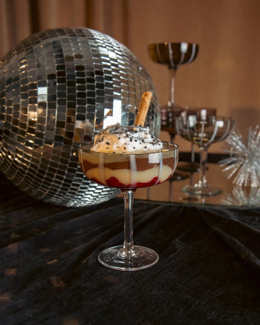 Dessert in a glass with a disco ball and other glasses in the background