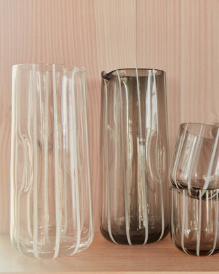 Set of clear glass vases on a wooden surface with a wooden wall background