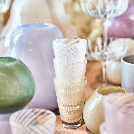 Decorative glassware and ceramic items on a wooden surface with a blurred background