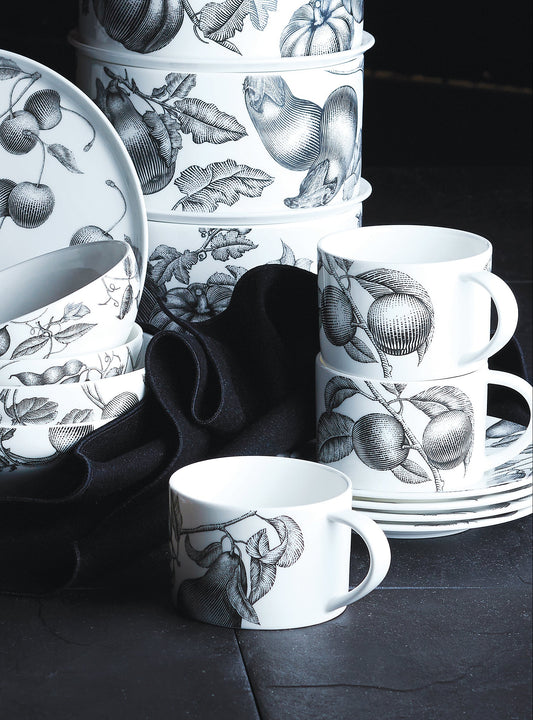 Set of ceramic dishes with black and white patterns on a dark surface.