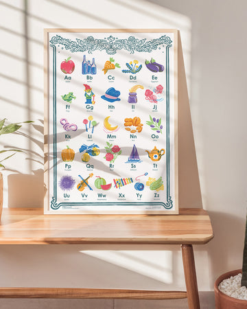 Children's alphabet chart on a wooden table with plants in the background