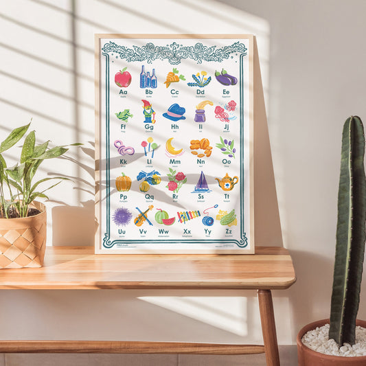 Children's alphabet chart on a wooden table with plants in the background