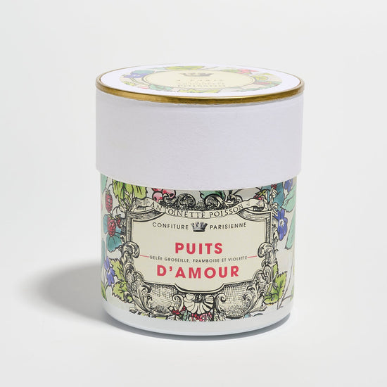 A jar with a floral illustrated label reading “Puits d’Amour” on a white background