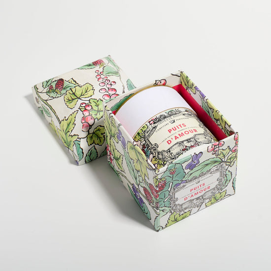 A jar packaged inside a floral illustrated box with the lid placed beside it