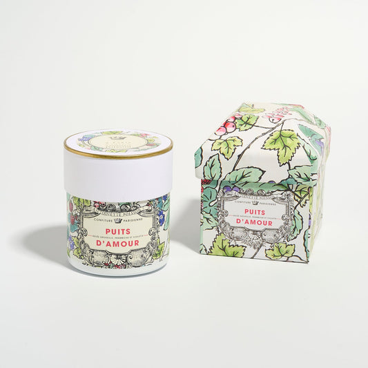A jar and a matching decorative box with floral illustrations and the label “Puits d’Amour” displayed side by side