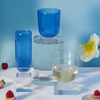 drinkware on the blue background with flower and strawberry