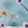 Stemless Wine Glass Petite in clear on the blue background with flowers