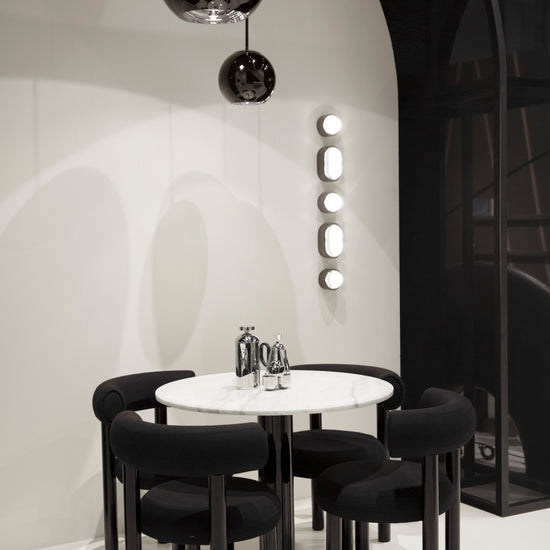 Modern black and white dining area with round table with brew cafetiere and chairs.