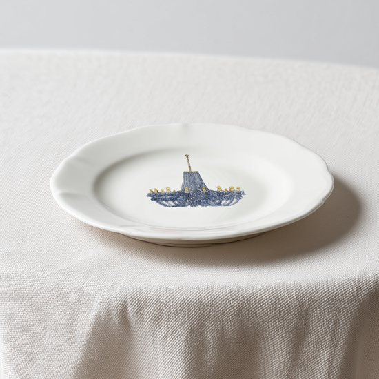 White plate with a blue ship design on a white tablecloth