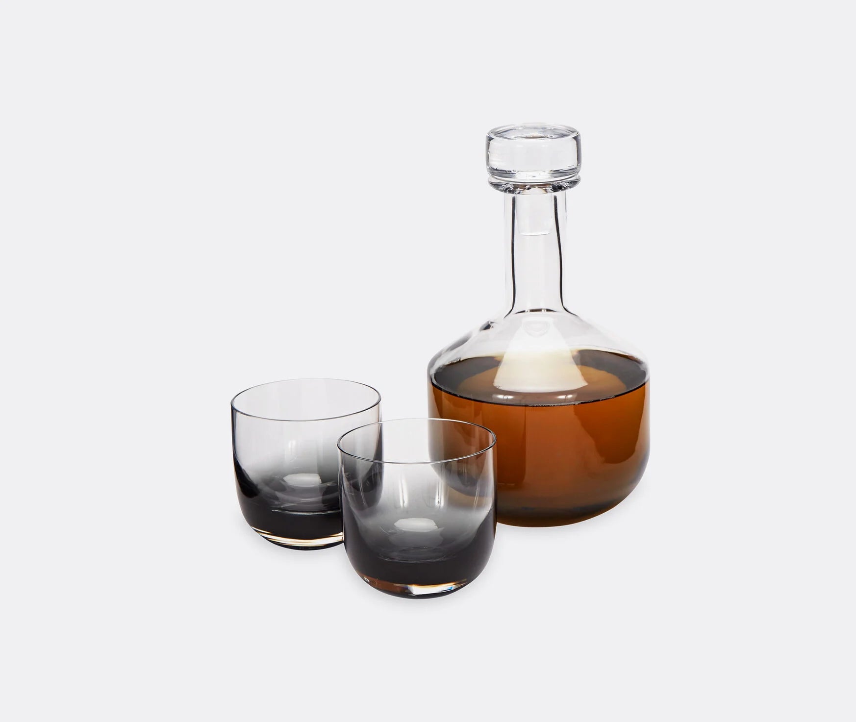 Glass decanter and two whiskey glasses on a white background