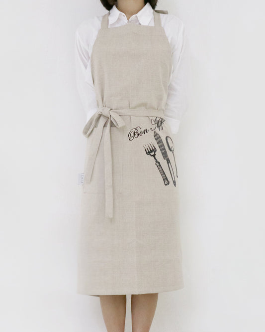 Person wearing a beige apron with graphic designs on a white background