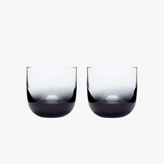 Two black whiskey glasses on a white background