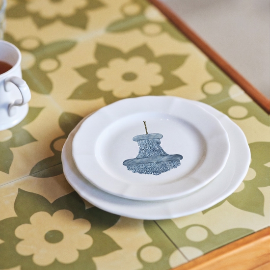 White plate with blue design on a floral tablecloth