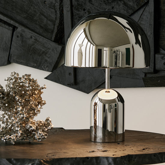 Silver table lamp on a wooden surface with a rustic background