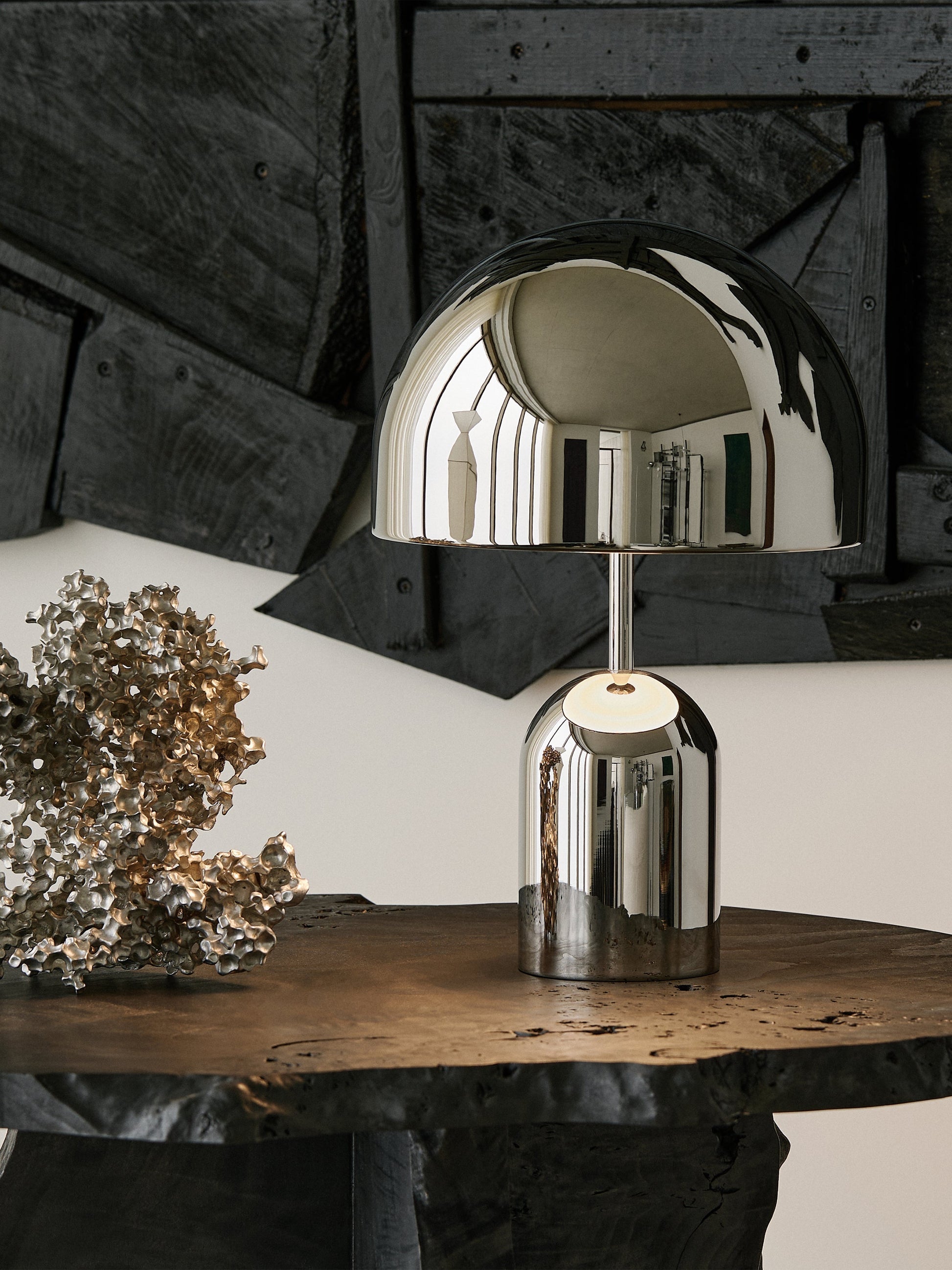 Silver table lamp on a wooden surface with a rustic background