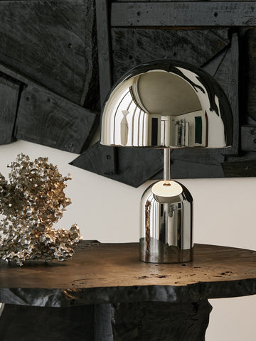 Silver table lamp on a wooden surface with a rustic background