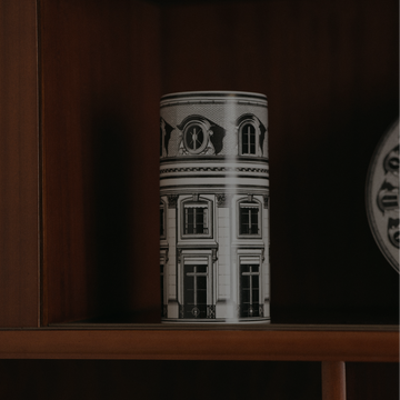 Vase with architectural design on a wooden shelf