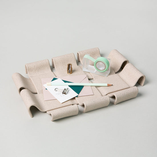 Sand-beige rectangular serving tray with curved handles resting on a white background