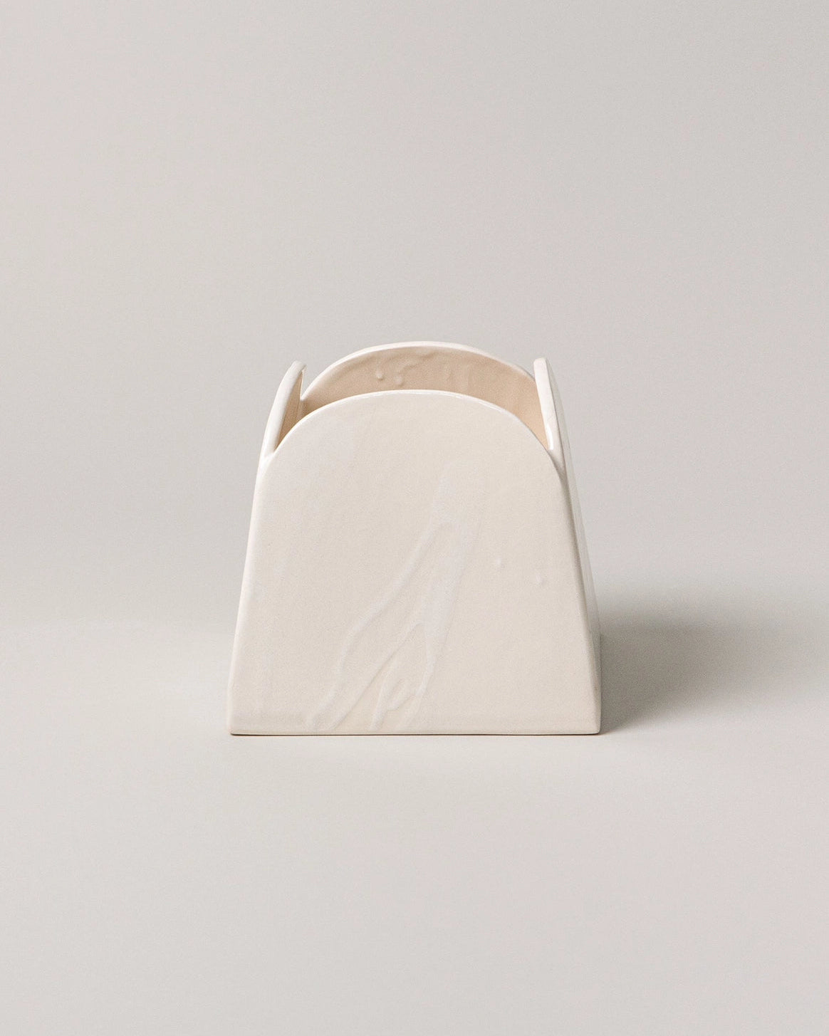 White ceramic vase with a textured surface on a light gray background