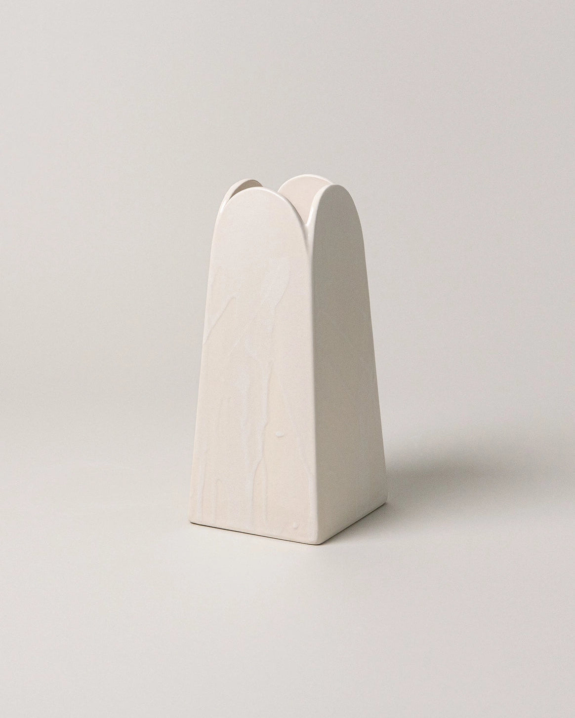 White ceramic vase with a unique design on a light gray background