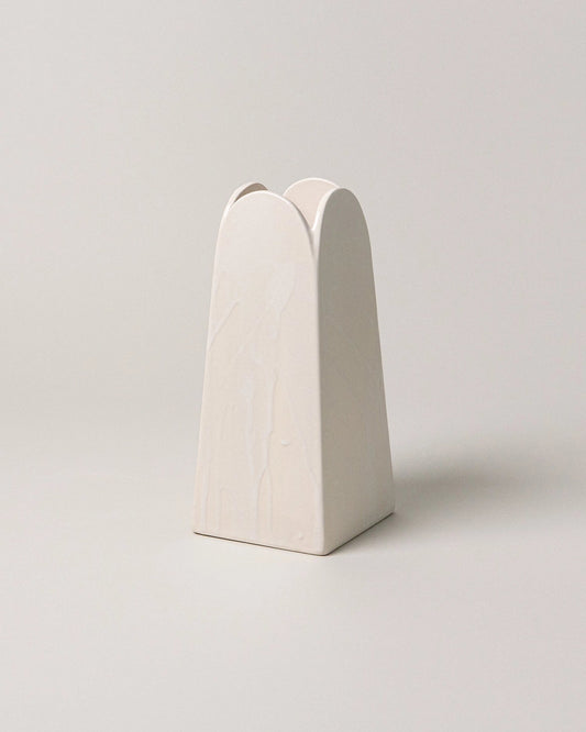 White ceramic vase with a unique design on a light gray background