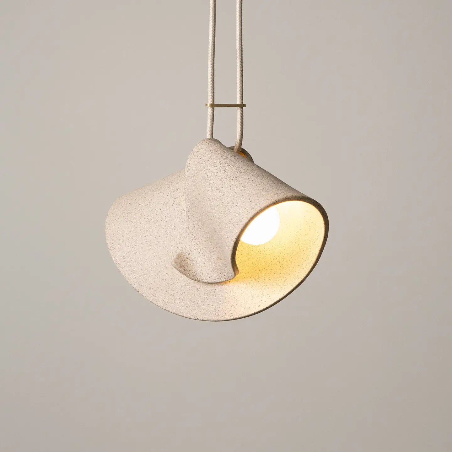 Modern pendant light with a beige shade on a neutral background