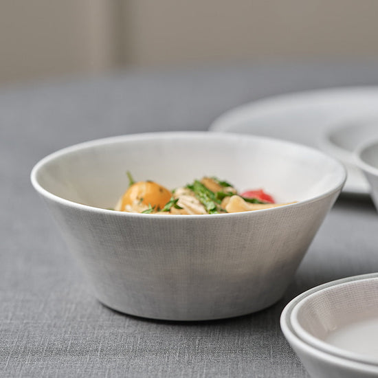 White ceramic bowls with food on a gray surface