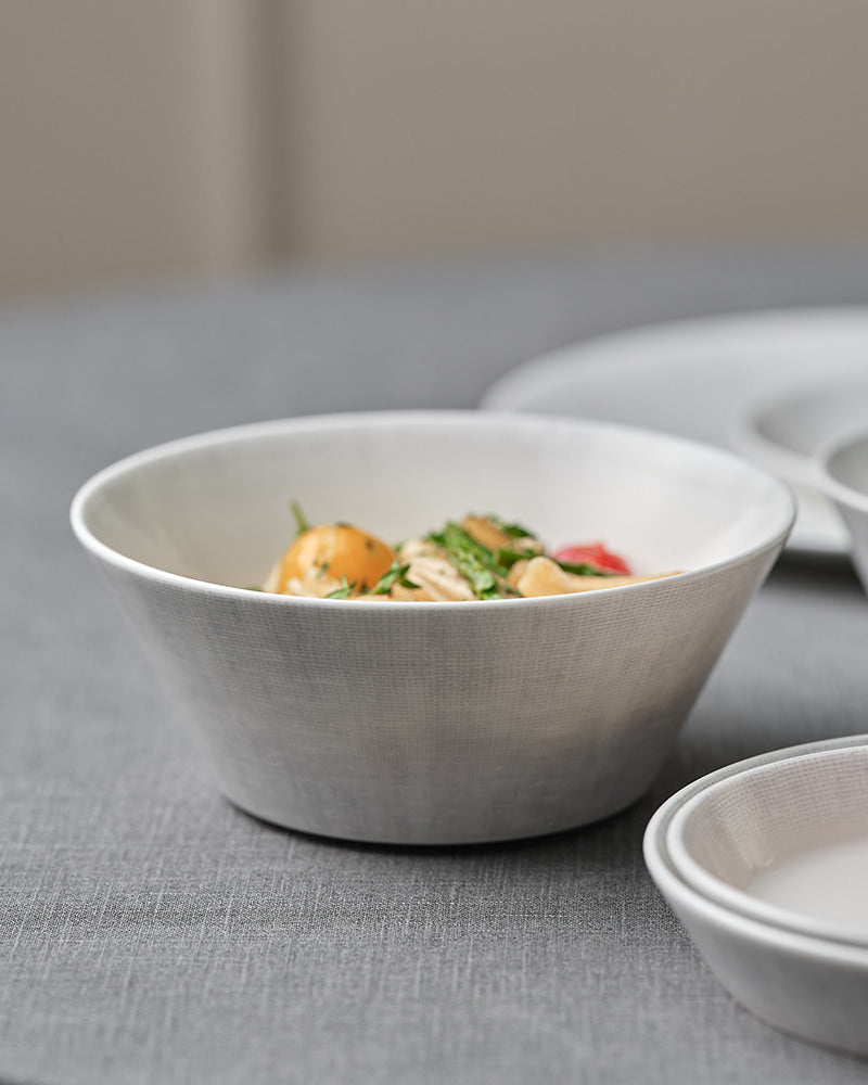 White ceramic bowls with food on a gray surface