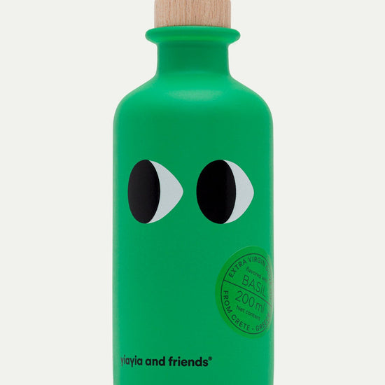 Green olive oil bottle with black and white eye design on a white background